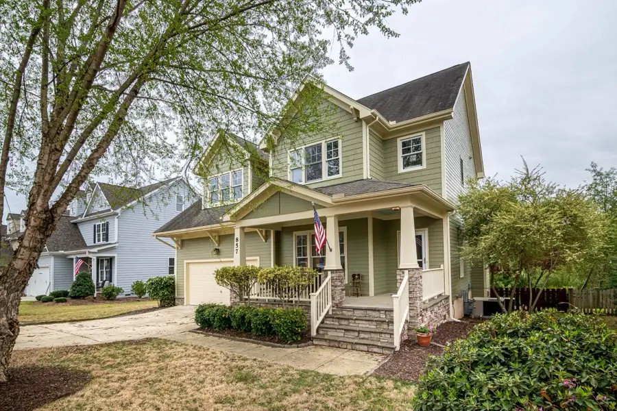 Sage green two-story home with a front porch and American flag
