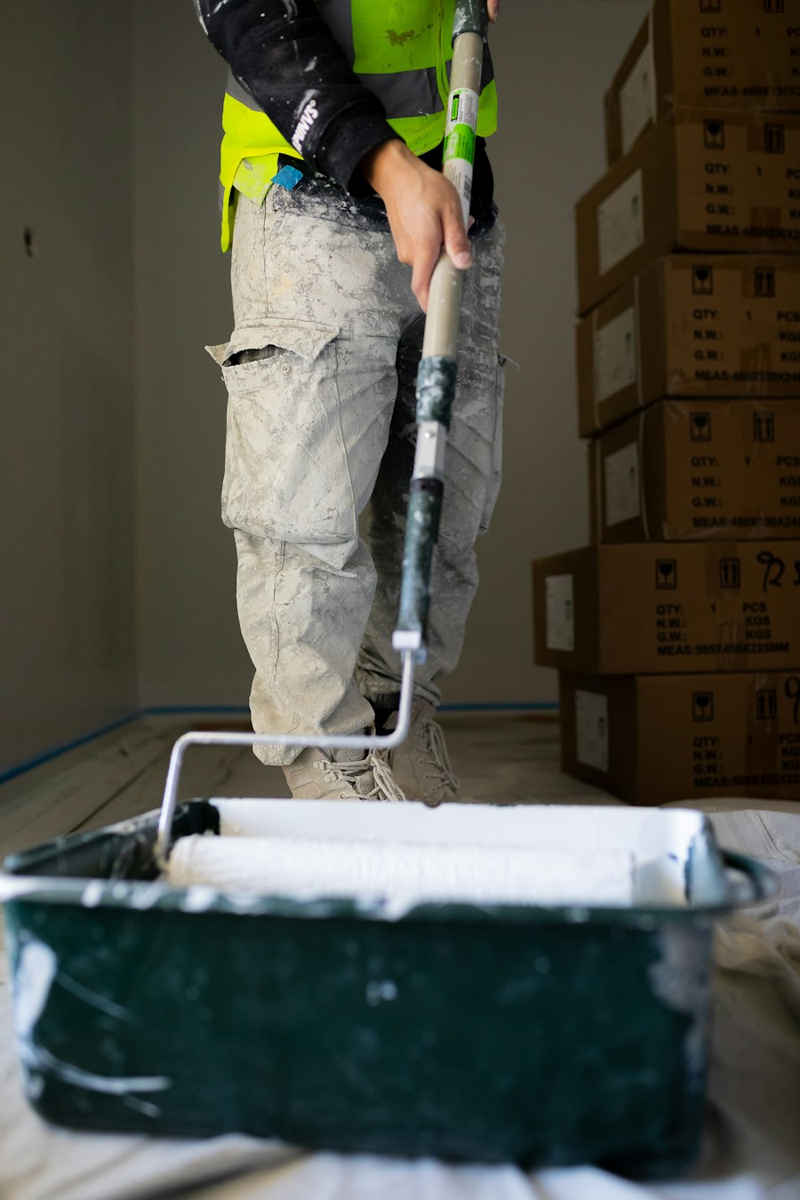 Painter rolling primer onto an interior wall