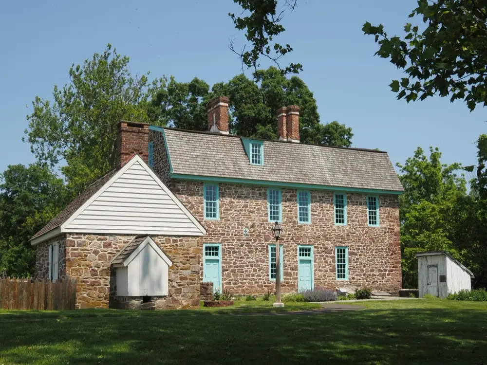 Fieldstone colonial farmhouse with a stone springhouse