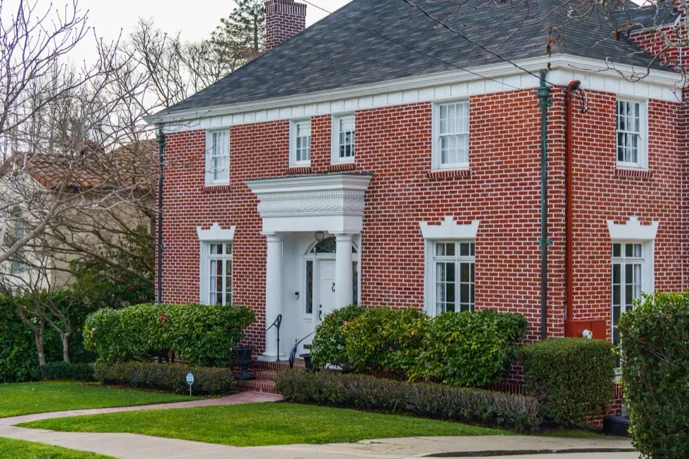 Red brick Colonial Revival home with a white portico