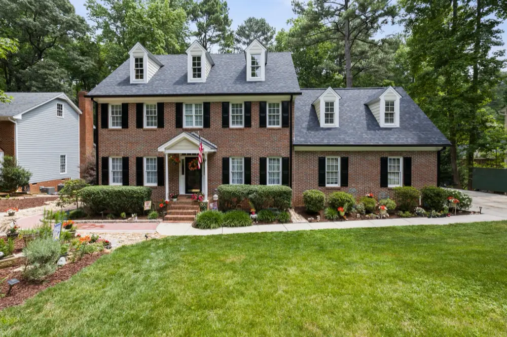 Brick colonial with dormers and black shutters